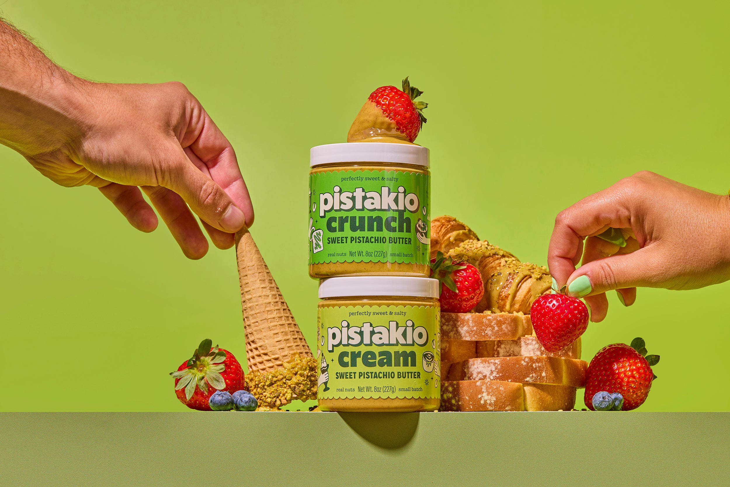 Pistakio spreads at the table with fresh strawberries and warm pastries